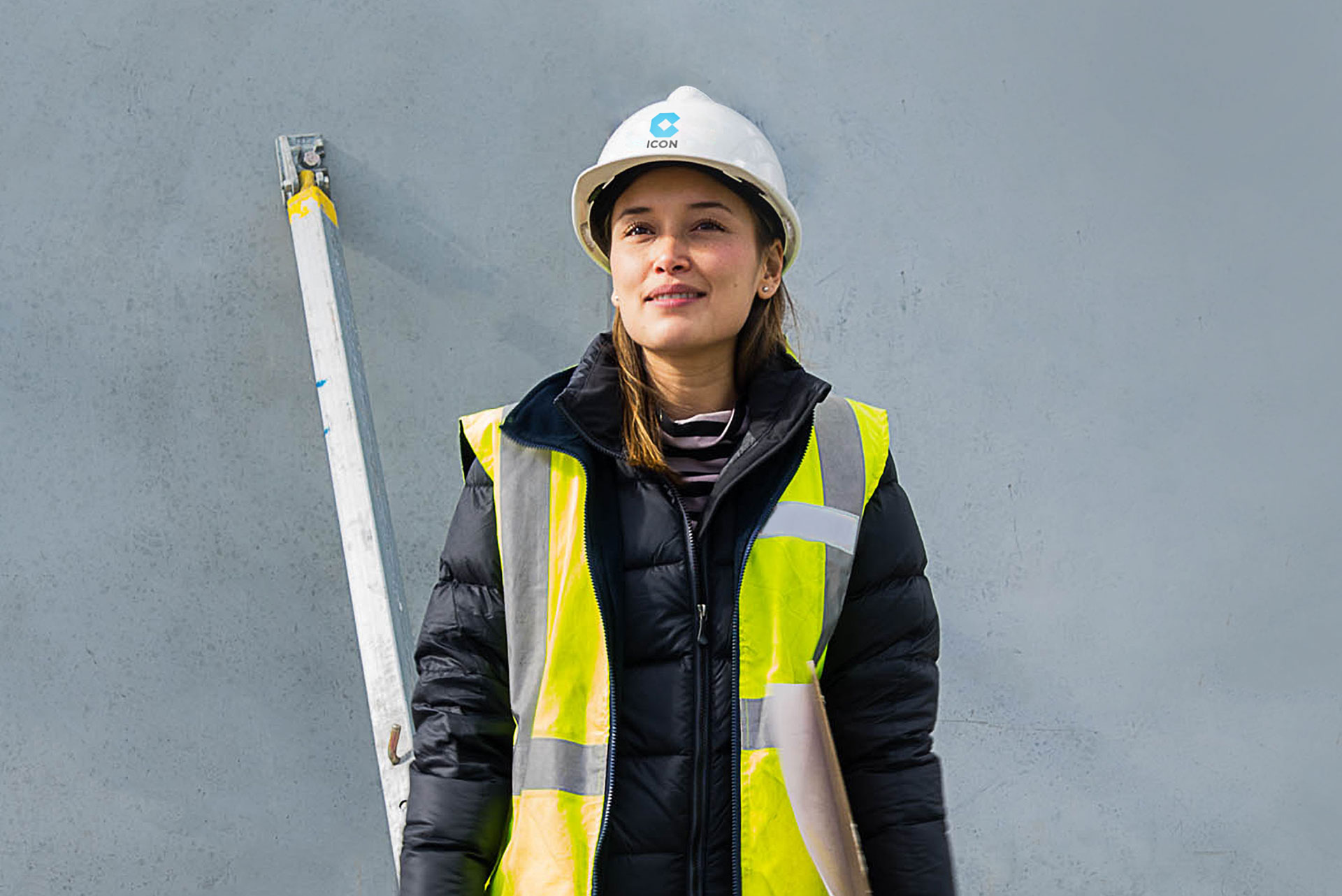 An Icon team member on site holding building plans