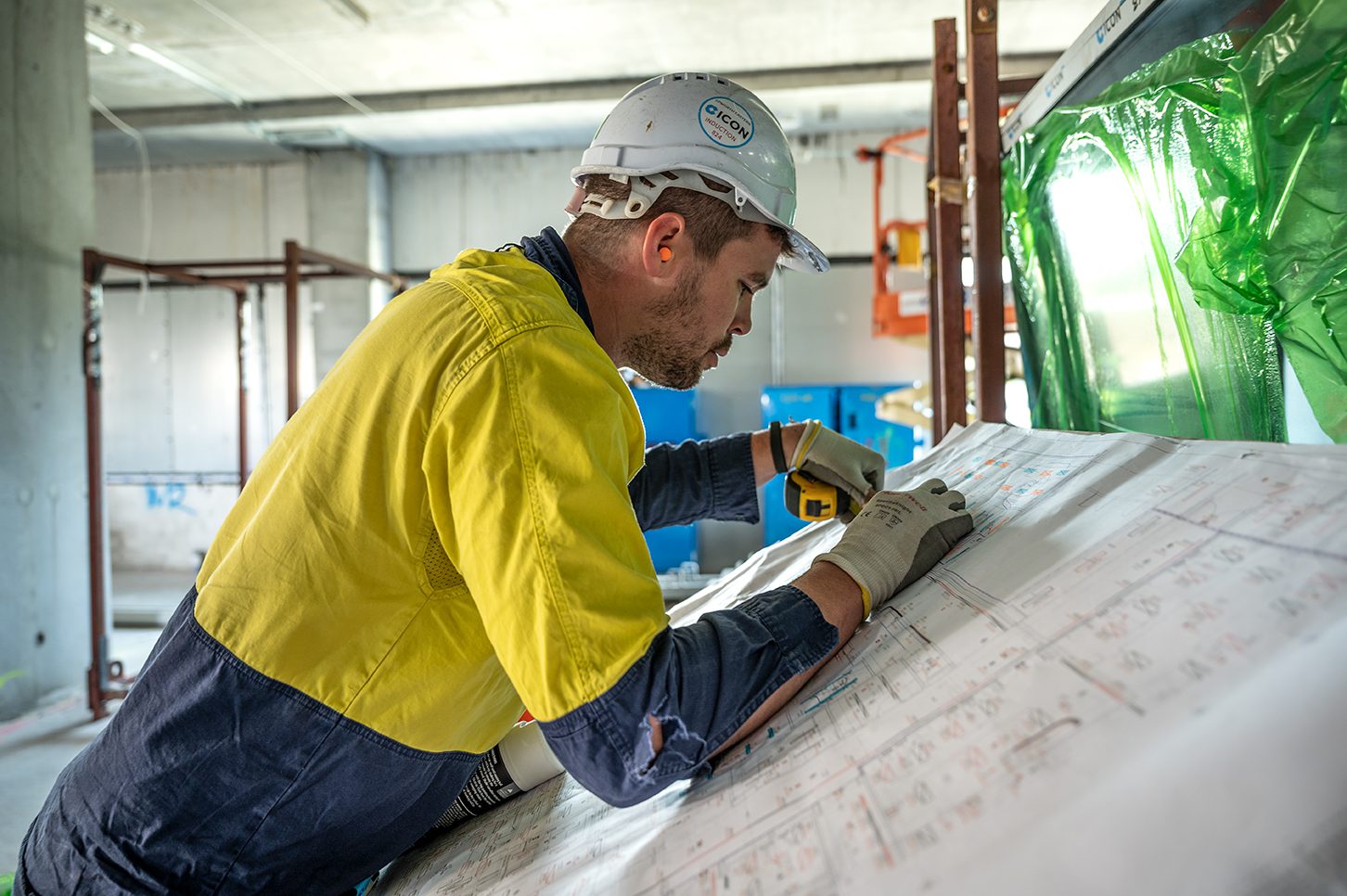 An Icon site team member reviewing construction drawings on site