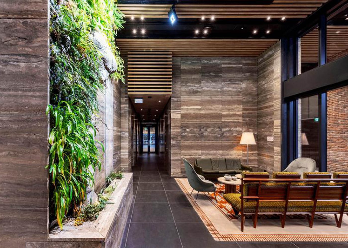 A living wall lines a timber-panelled Icon building interior